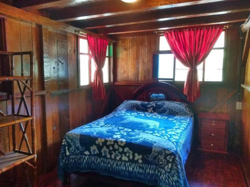 - une chambre avec un lit dans une pièce en bois dans l'établissement Casa en el rincon familiar en Mindo, à Mindo