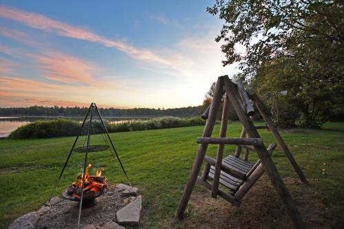 a fire pit with a swing and a fire pit at Scenic & Serene Lakefront Cottage With Wood Stove in Crivitz