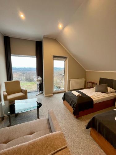 a bedroom with two beds and a couch and a window at Willa Hańcza 1 in Kleszczówek