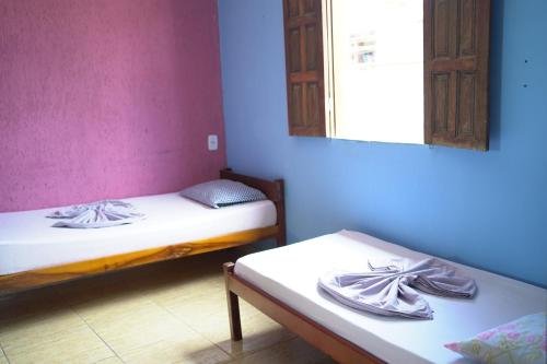 2 camas en una habitación con espejo en Porto Hostel, en Porto Seguro