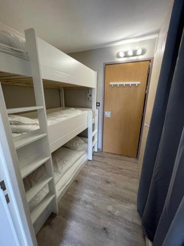 Cette chambre comprend 2 lits superposés et une porte. dans l'établissement Appartement 4 personnes aux pieds des pistes Wifi Netflix, à Les Deux Alpes