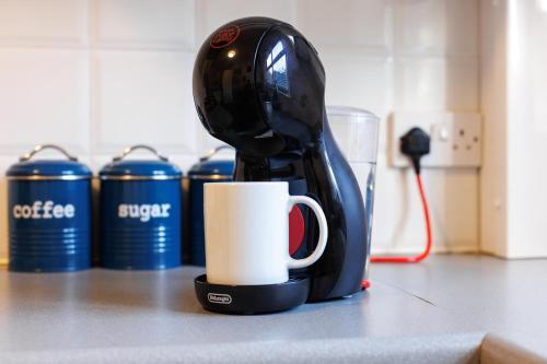 eine Kaffeemaschine auf einer Theke mit einer Tasse in der Unterkunft FLATZY - Quiet Sefton Park Luxury Apartment in Liverpool