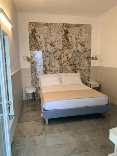 een slaapkamer met een bed met een muur bij San Pietro Home in San Pietro in Bevagna
