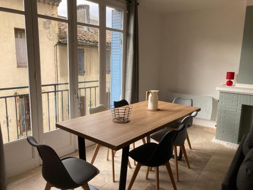 - une table et des chaises en bois dans une chambre avec fenêtre dans l'établissement CARC'APPART Appartements à Carcassonne, à Carcassonne