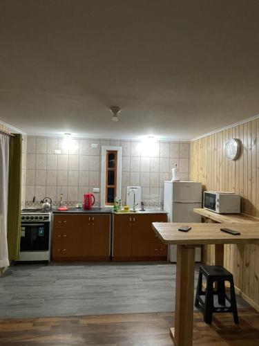 una cocina con armarios de madera y una mesa. en Cabañas Rukafun 2 en Pucón