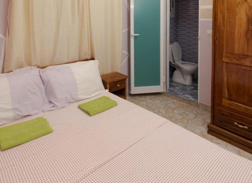 ein Schlafzimmer mit einem Bett mit zwei grünen Handtüchern darauf in der Unterkunft Maison Bethel Kpogan Afidenigba 