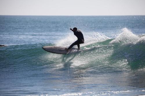 a man riding a wave on a surfboard in the ocean at Boilers Surf House in Tamri