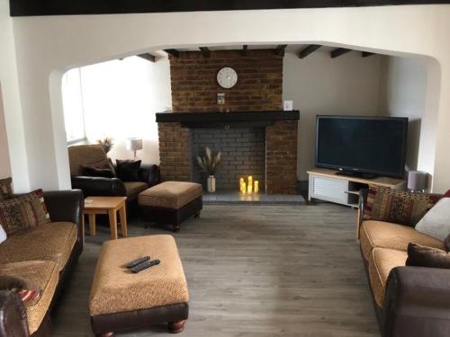 sala de estar con chimenea y TV en A Bright and Spacious Gem-Newly renovated house en Staines