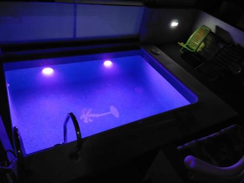 uma piscina com iluminação azul num quarto em Oasis em Arcos de la Frontera