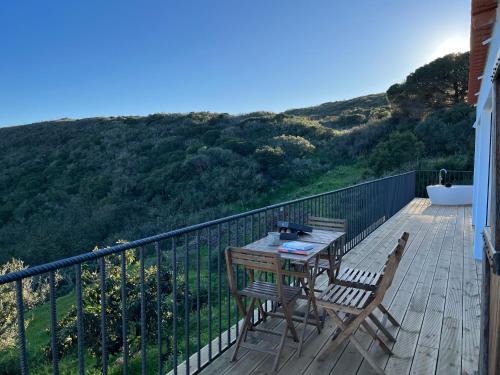 a wooden deck with a table and chairs and a bath tub at Nature&Soul - MAR in Vila do Bispo
