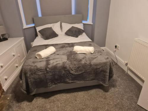 a bedroom with a bed with two towels on it at Primrose Stays - 3 bedroom House in Stoke on Trent