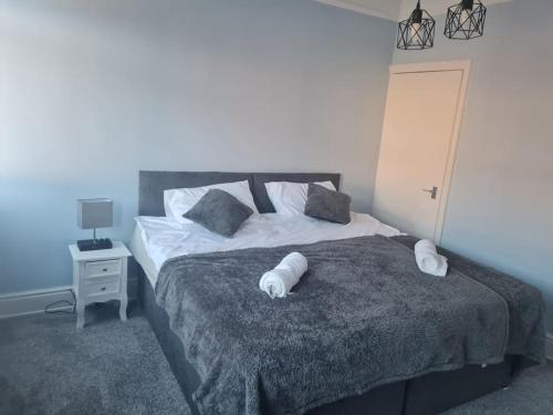a bedroom with a bed with two pillows on it at Primrose Stays - 3 bedroom House in Stoke on Trent