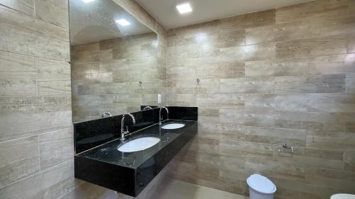 een badkamer met 2 wastafels in een stenen muur bij Canoa Azul in Garapuá