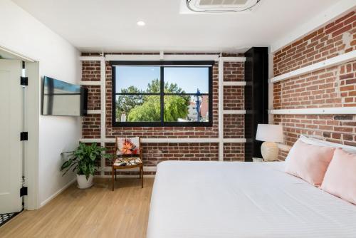 a bedroom with a brick wall and a bed at The Brick Boutique Hotel in Oceanside