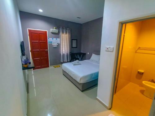 una habitación de hotel con una cama y un baño en Bonda Room Stay Langkawi, en Pantai Cenang