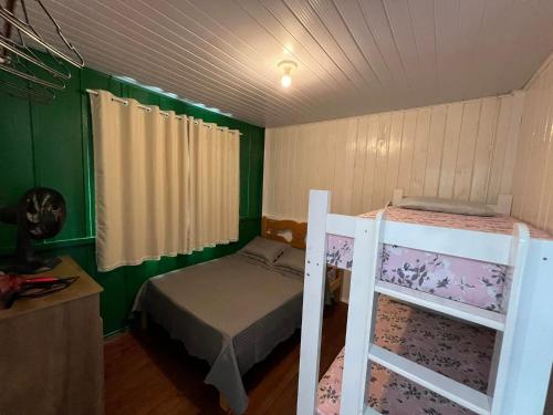 a bedroom with a bunk bed and a ladder at Casa Suzena 300 metros Parque e Praias in Penha
