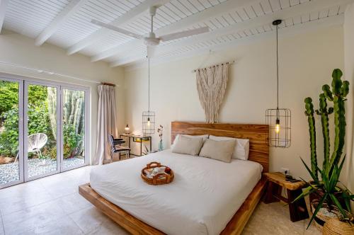 een slaapkamer met een groot bed met een houten hoofdeinde bij Naïma Luxury Home, Cottage & Apartment Rentals in Paradera