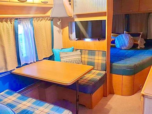 a room with a table and a dining table in an rv at Caravanas Con Encanto El Palmar 2 in El Palmar