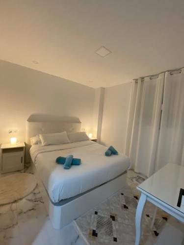 a bedroom with a white bed with blue bows on it at Modern appartment Palma in Palma de Mallorca