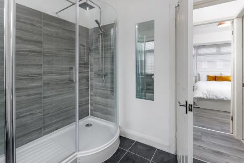 a bathroom with a shower and a tub and a bed at The Empress 2 Bed Terraced House in Liverpool