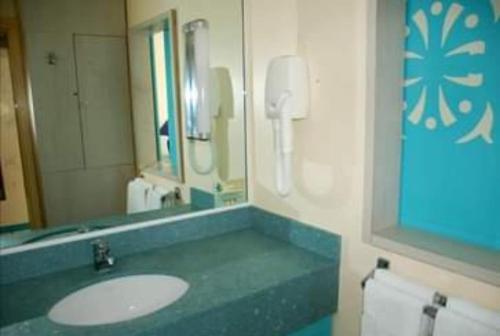 La salle de bains est pourvue d'un lavabo et d'un miroir. dans l'établissement Studio dans Résidence Hotelière aux 3ilets Pointe du bout Résidence la Marina Carayou, à Les Trois-Îlets