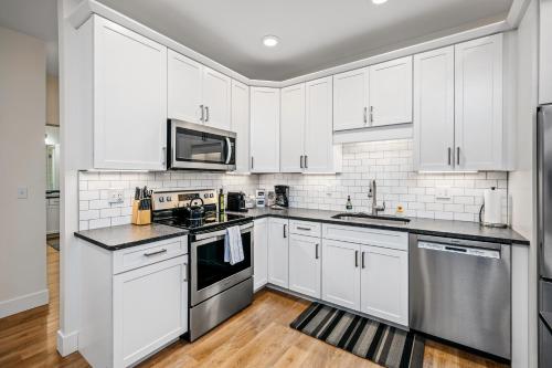 a kitchen with white cabinets and stainless steel appliances at Urban Escape in Downtown Traverse City in Traverse City