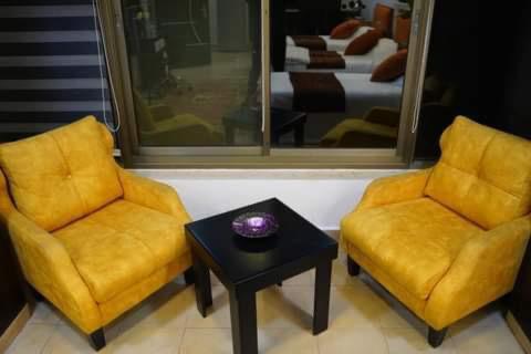 ラマッラーにあるDaniel Studio #1の黄色い椅子2脚とテーブル1台