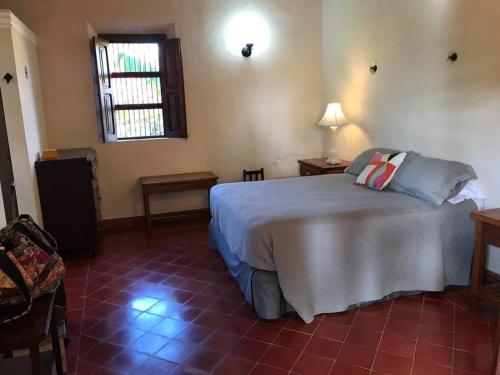 Un dormitorio con una cama grande y una ventana en Private Restored Hacienda With Its Own Cenote, en Espita