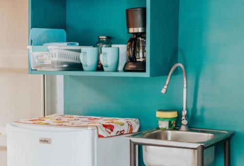 a kitchen with a sink and a blue wall at Wanderlust in Jacó