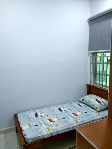 a bedroom with a bed with a blue comforter at ISMAYUS GUESTHOUSE in Kampong Chinchang