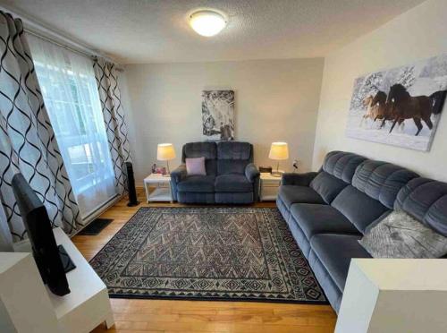 uma sala de estar com um sofá e uma cadeira em 3 Bedrooms cozy comfortable vacation home downtown Gatineau Ottawa near Parliamant and Park em Gatineau