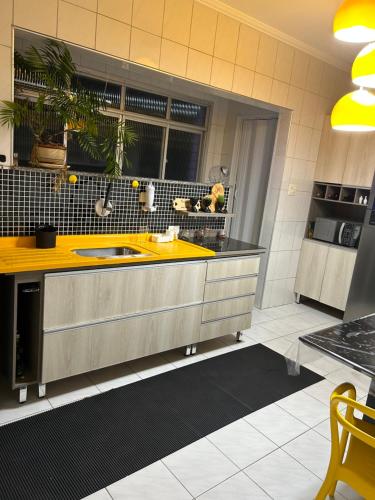a kitchen with a sink and a yellow counter top at APTO FRENTE PARA MAR BOQUEIRÃO - PRAIA GRANDE in Praia Grande