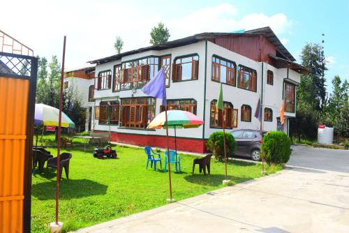 a house with chairs and umbrellas in front of it at Gulsitara Resorts-Gulmarg in Gulmarg