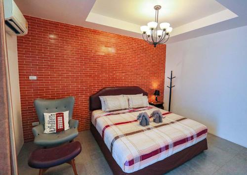 a bedroom with a bed and a brick wall at Jamjuree Home at Udonthani in Udon Thani