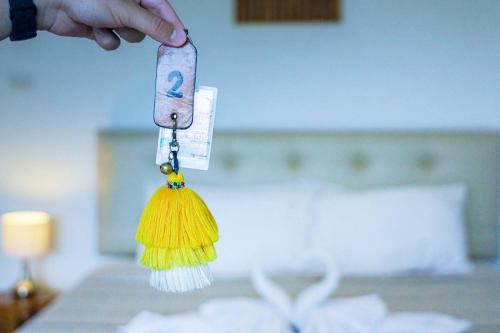 a persons hand holding a tassle in a bedroom at Jamjuree Home at Udonthani in Udon Thani