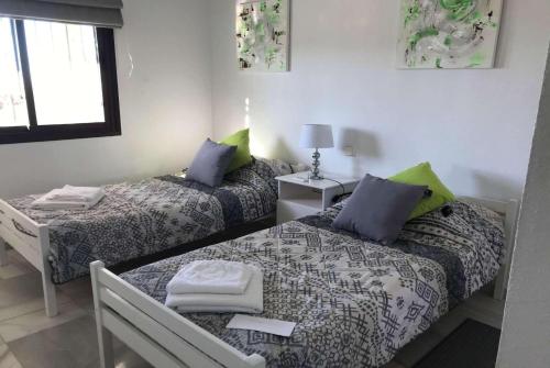 ラ・カラ・デ・ミハスにあるCasa Bunjiのベッド2台とテーブルが備わる客室です。
