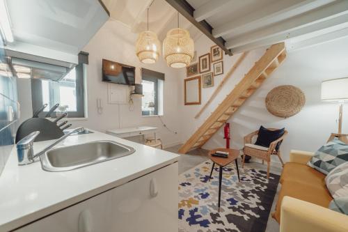 a kitchen with a sink and a living room at Mezzanine Stylish Apartments by Vacationy in Porto