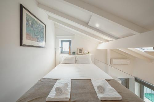 a bedroom with a large bed in a white room at Mezzanine Stylish Apartments by Vacationy in Porto