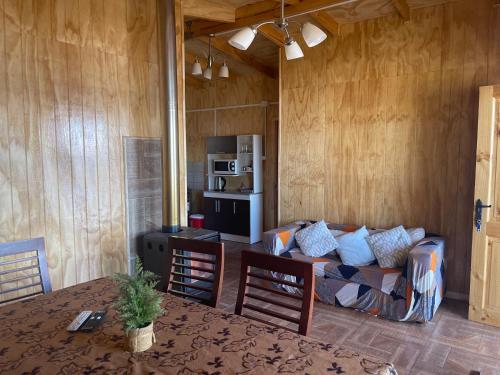 a living room with a couch and a table at Cabañas y Tinajas Rio Quenuir in Maullín