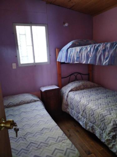 a bedroom with two bunk beds and a window at Cabañas Matanzas Noemi in Boca Pupuya