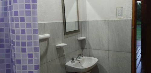 a bathroom with a sink and a shower curtain at Cabañas Las Acacias in Colonia Las Rosas