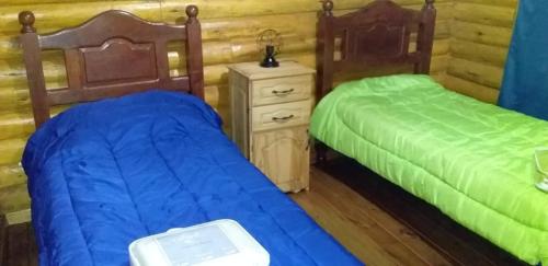 Colonia Las RosasにあるCabañas Las Acaciasのベッド2台が隣同士に設置された部屋です。