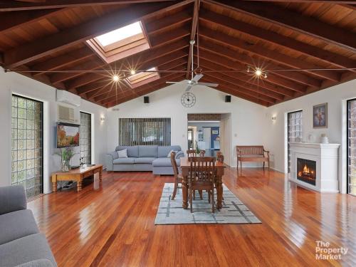 sala de estar con mesa y chimenea en Mannering Lake House, en Mannering Park