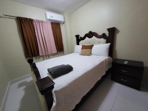 a bedroom with a large bed with a wooden headboard at Hermoso y comodo apartamento in Santiago de los Caballeros