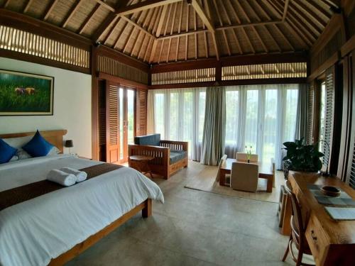 Villa & Farm for 5, near Sidemen w/ Mt. Agung View في Selat: غرفة نوم بسرير كبير في غرفة بها نوافذ