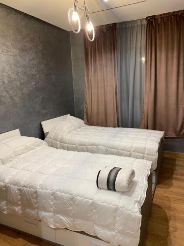 马拉喀什Appartement a loué pour les familles的卧室里有两张床，铺着白色床单
