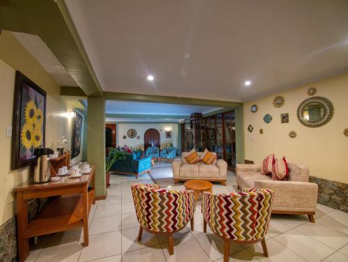a living room with couches and a table and chairs at Sol Ollantay Exclusive Hotel in Ollantaytambo