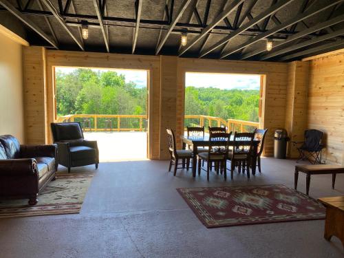 un soggiorno con tavolo, sedie e una grande finestra di Smoky Hollow Outdoor Resort Covered Wagon a Sevierville