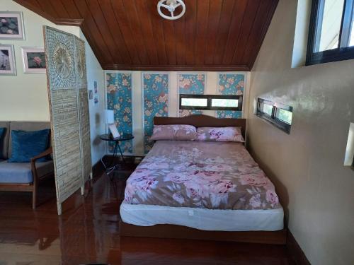 een slaapkamer met een bed en een stoel bij Baguio Rest House in Baguio
