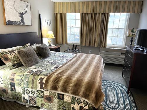 Un dormitorio con una cama con una manta. en Ski On Off 1BR Suite 1st Flr Sleeps 4 Jiminy Peak, en Hancock
